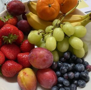 a picture of grapes, plums, oranges, blueberries, strawberries, and bananas